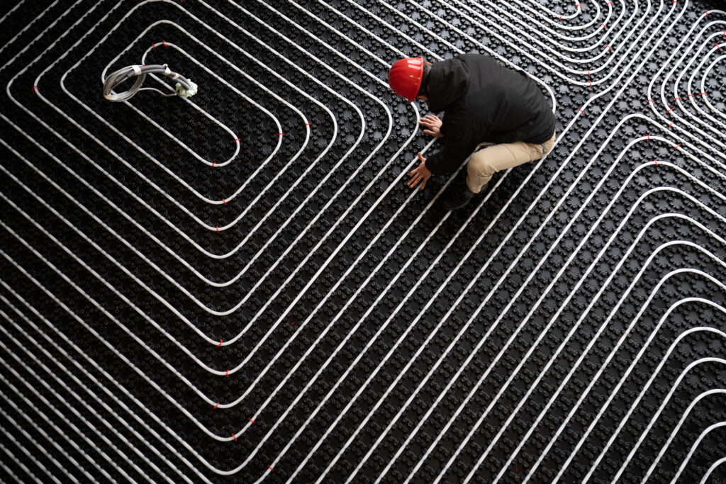 Worker adjusting position of pipes, diagonally oriented pattern on tubes